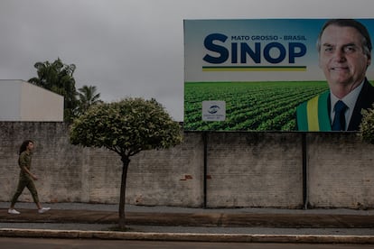 Un peatón camina bajo un cartel de apoyo al presidente en Sinop, cuna de la industria de la soja y bastión electoral del bolsonarismo. 