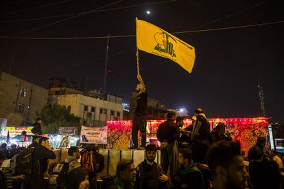 En la madrugada de Kerbala, un militante de Hezbolá ondea una bandera de guerra de la organización libanesa.