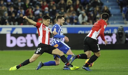 Dos jugadores del Athletic disputan un balón a uno del Alavés.