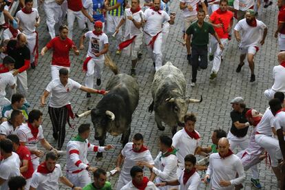 Dos toros de la ganadería Cebada Gago corren entre los participantes por las calles de Pamplona.