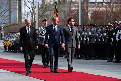 Desde la izquierda, el canciller alemán, Olaf Scholz; el primer ministro polaco, Donald Tusk, y el presidente francés, Emmanuel Macron, pasan revista a las tropas este viernes en Berlín.