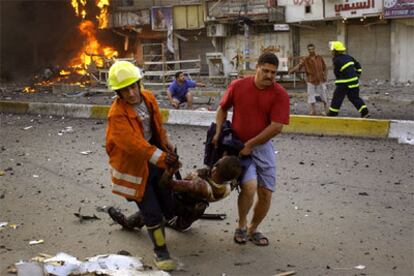 Los equipos de rescate atienden a los heridos tras una de las explosiones de ayer en Bagdad.