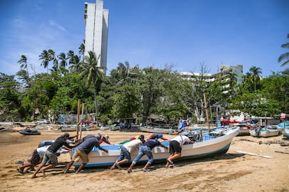 Pescadores trasladan una embarcación previo a la llegada del huracán 'Erick', este miércoles, en el balneario de Acapulco, Guerrero.