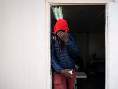 Bacary Camará, 35 años,  procedente de Senegal se tapa la cara en la puerta de la cafetería habilitada en el exterior del albergue temporal instalado por le Ayuntamiento de Nijar tras el desalojo del campamento el Walili, Almería.