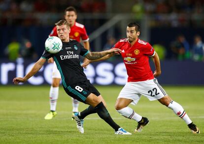 Toni Kroos (centro) controla el balón ante el jugador del Manchester, Henrikh Mkhitaryan.