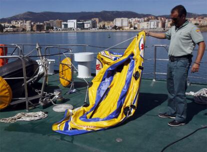 Un guardia civil sujeta una balsa de juguete similar a la que usaron seis menores para intentar alcanzar la costa de Cádiz.