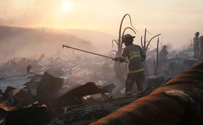 Bombeiro entre os escombros de um incêndio em Valparaíso.