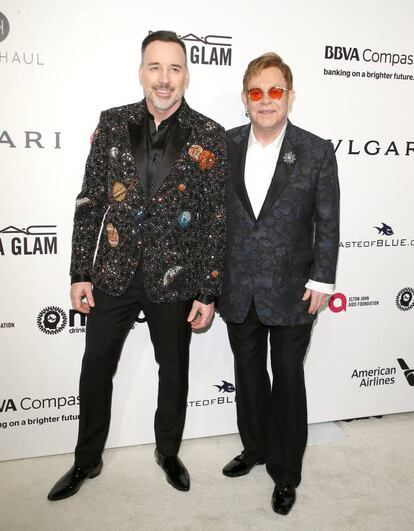 Elton John y su esposo David Furnish, en la alfombra roja de la fiesta que el cantante británico organiza para racudar fondos para su fundación que lucha contra el sida.