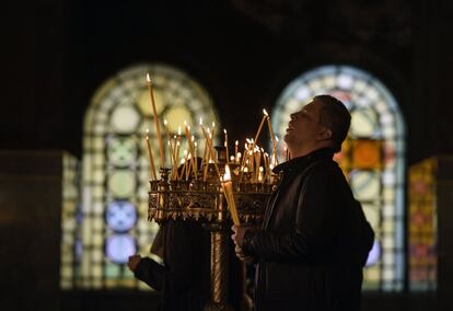 Un hombre enciende velas durante la misa de Navidad en la Catedral de San Alexander Nevski en Sofía (Bulgaria), el 25 de diciembre de 2018.