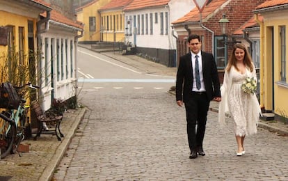 Una pareja de recién casados pase por el pueblo de ærøskøbing (Dinamarca).
