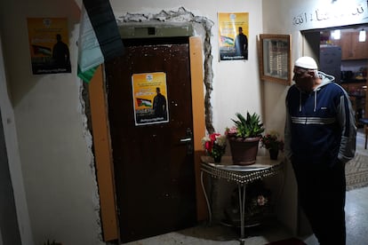 Imad Atshan, a la puerta de su vivienda en Ramala junto a carteles de su hijo Omar Atshan, un preso palestinos de 19 años liberado el domingo por Israel.