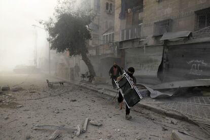 Un hombre se lleva una silla, en una de las calles afectadas por los bombardeos, en el barrio de Al-Ansari en Alepo (Siria), 31 de enero de 2014.