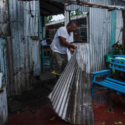 A man remove parts of a damaged construction caused by the landfall of Hurricane Grace in Tecolutla, Veracruz, Mexico, on August 21, 2021. - Hurricane Grace lashed eastern Mexico with heavy rain and strong wind on Saturday, causing flooding, power blackouts and damage to homes as it gradually lost strength over the mountainous interior. (Photo by VICTORIA RAZO / AFP)