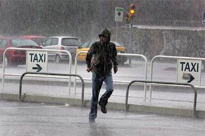 Un hombre corriendo bajo la lluvia ayer por la mañana en los alrededores de la etsación de Renfe de Sants.