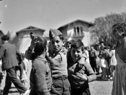 Tres niños delante de un palacio convertido en escuela, en 1937.