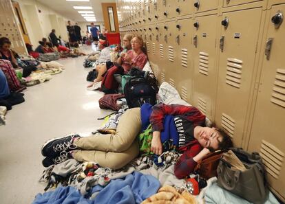 Emily Hindle descansa en el piso de un albergue improvisado en Rutherford High School durante el paso del huracán.