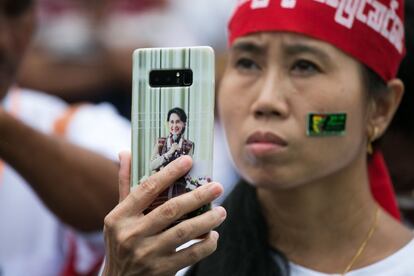 Una mujer sostiene un teléfono móvil con una imagen de la consejera estatal de Myanmar, Aung San Suu Kyi, durante una protesta en apoyo de las enmiendas a la Constitución de Myanmar de 2008, en Rangún (Myanmar) el 17 de julio de 2019.