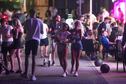 Varios turistas pasean por una zona de copas de Magaluf, en Mallorca.