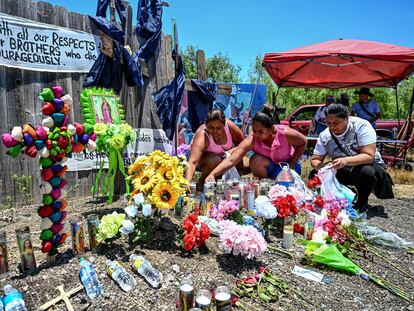 Mujeres dejan flores y velas cerca del sitio donde fueron hallados los cuerpos de los migrantes.