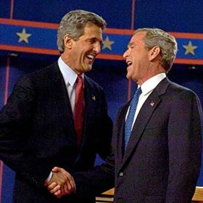 Kerry y Bush se saludan instantes antes del comienzo del debate televisado.