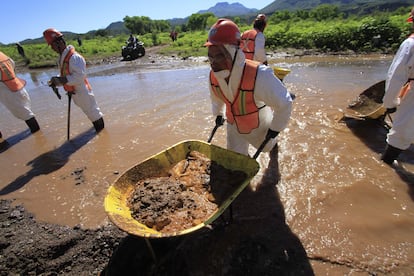 Un grupo de trabajadores de Grupo México y del Estado de Sonora limpian la zona del derrame mezclando la tierra contaminada con cal, para neutralizar los ácidos, en Cananea (Sonora), en 2014.