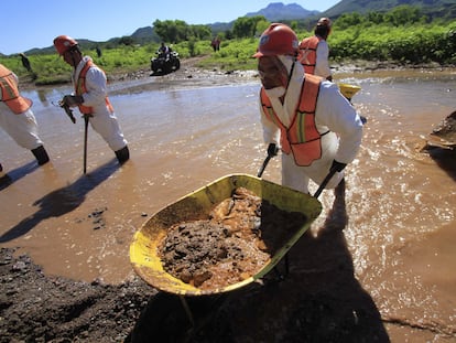 Un grupo de trabajadores de Grupo México y del Estado de Sonora limpian la zona del derrame mezclando la tierra contaminada con cal, para neutralizar los ácidos, en Cananea (Sonora), en 2014.