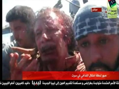 Imagen tomada de un vídeo en la que se ve a Gadafi aún vivo, poco después de ser apresado en Sirte.