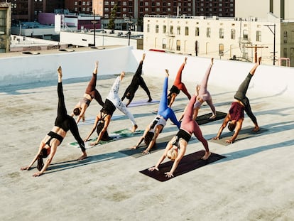 Elevated view of yoga class practicing on rooftop overlooking city