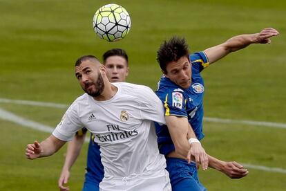 El delantero francés del Real Madrid Karim Benzema (i) disputa un balón con el defensa argentino del Getafe Santiago Vergini (d).