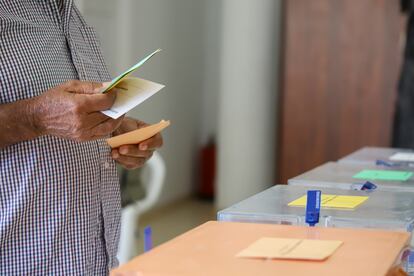 Un hombre sostiene sus papeletas de votación ante las urnas de la mesa en un colegio electoral de la isla de La Palma, el pasado domingo.