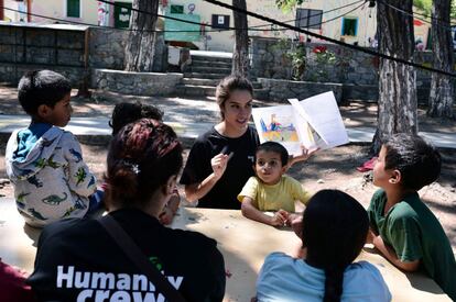 Niños refugiados prestan atención al cuento de una voluntaria en PIKPA village, en la isla de Lesbos (Grecia).