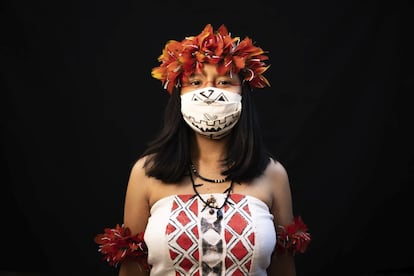 Yusuro Dupohtiro, de 15 años, de los grupos étnicos indígenas dessana y sateré mawé, posa para un retrato con la ropa y tocado tradicionales de su tribu y una máscara facial, el miércoles 27 de mayo de 2020.