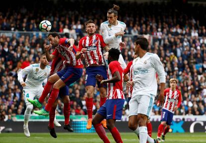 Bale y Saúl, intentan controlar la pelota ante sus compañeros.