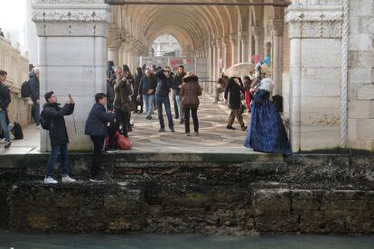 Turistas toman fotos durante el fenómeno de marea baja en Venecia, el día 17 de febrero. Los canales llevan así casi un mes a causa de las bajas mareas y las pocas precipitaciones.