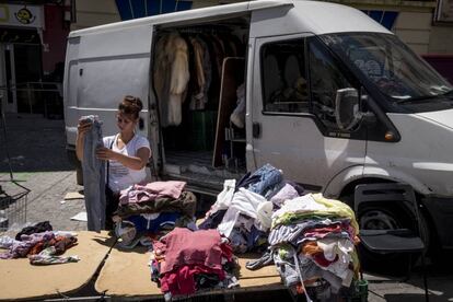 Una mujer recoge la mercancía de su puesto del Rastro.