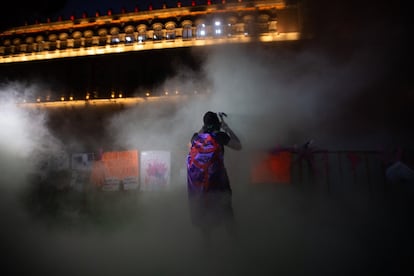 Una mujer protesta en medio del gas de extintor de fuego frente a Palacio Nacional. 