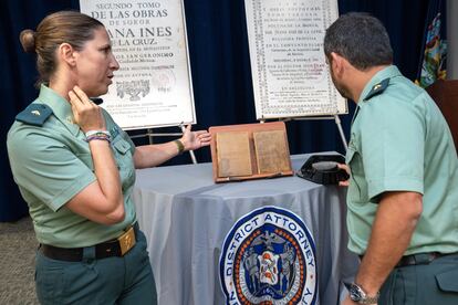 Dos agentes de la Guardia Civil, los comandantes Cristina Andreu y Roberto Tirado, muestran los dos libros de sor Juana de la Cruz, recuperados en Estados Unidos.