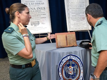 Dos agentes de la Guardia Civil, los comandantes Cristina Andreu y Roberto Tirado, muestran los dos libros de sor Juana de la Cruz, recuperados en Estados Unidos.