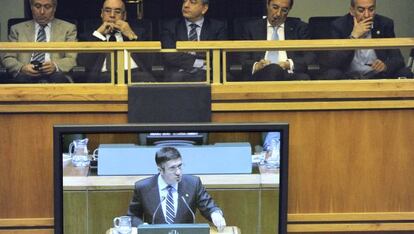 La imagen del 'lehendakari', en una de las pantallas del Parlamento vasco. Al fondo, el delegado del Gobierno en Euskadi, Miguel Ángel Caviedes, el presidente del Senado, Javier Rojo, el diputado general de Álava (PP), Javier de Andrés, el de Bizkaia (PNV), José Luis Bilbao y el de Gipuzkoa (Bildu), Martin Garitano.