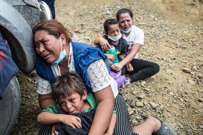 Una migrante llora junto a su hijo luego que la Policía disolviera la caravana de miles de personas que bloqueba la carretera de Vado Hondo, Chiquimula.