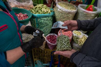 Personas compran frutas y verduras, en la plaza de mercado Paloquemao, en Bogotá