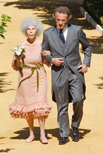 La Duquesa de Alba se ha casado con un diseño de Victorio & Lucchino en color rosa pálido, que ha combinado con cinta de terciopelo verde en la cintura. Alfonso Díez ha optado por un chaqué clásico. 