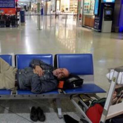 Un pareja descansa en un banco de la terminal de salidas del aeropuerto internacional "Elefterios Velizelos" en Atenas (Grecia), hoy, 24 de febrero de 2010.