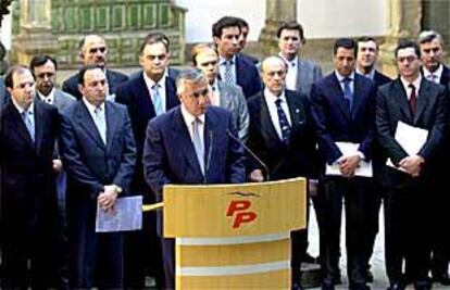 Javier Arenas, secretario general del PP, lee el documento sobre financiación autonómica arropado por otros dirigentes de su partido.