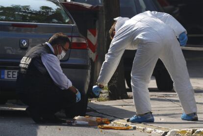 Policías griegos inspeccionan restos de un paquete bomba detonado
