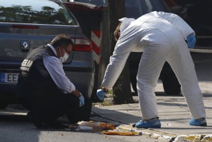 Policías griegos inspeccionan restos de un paquete bomba detonado