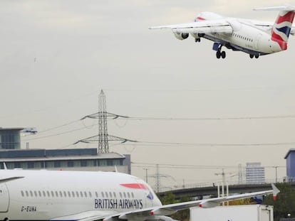 Un avión de British Airways -una de las empresas denunciadas por discriminación- espera para despegar, mientras que el otro ya ha despegado.