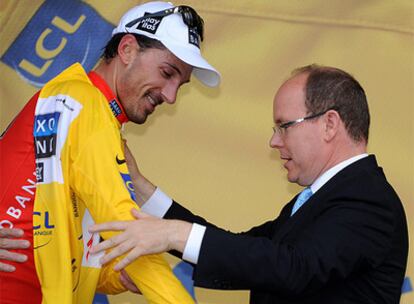 El Príncipe Alberto de Mónaco viste a Fabian Cancellara con el 'maillot' amarillo.