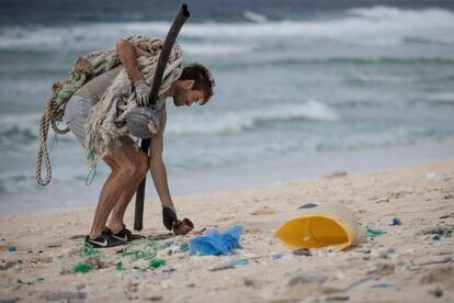 Un hombre, miembro de un grupo de voluntarios medioambientalistas, recoge residuos en una playa de la isla deshabitada de Henderson, en el sur del Océano Pacífico.