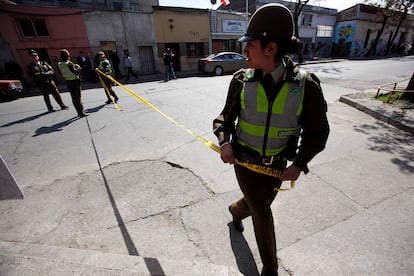 Una funcionaria de Carabineros colocando una cinta de seguridad en una calle de Santiago de Chile.